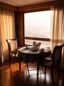 a dining room with a table and chairs and a window at Hotel Peregrino Suites in Concepción