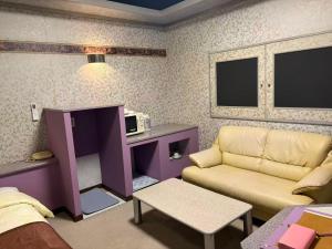 a living room with a couch and a table at ホテルＪoＪo in Ikaho