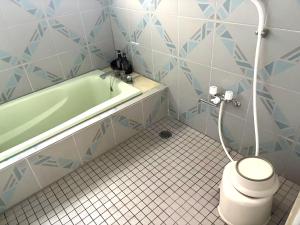 a bathroom with a tub and a toilet and a sink at ホテルＪoＪo in Ikaho