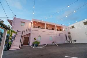 a pink building with a balcony on top of it at Room 4: Minimalist Bunk Room w/ Free Parking | San Juan in San Juan
