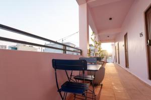 a balcony with chairs and a table in a building at Room 4: Minimalist Bunk Room w/ Free Parking | San Juan in San Juan