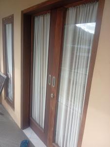 a pair of glass doors in a room at Mamat warung bed & breakfast in Huu +5 photos