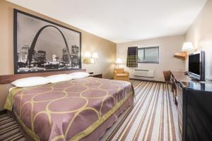 a hotel room with a bed and a tv at Super 8 by Wyndham Nevada in Nevada