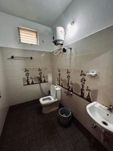 a bathroom with a toilet and a sink and a light at AURO BAY inn in Kuilapayam
