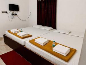 a bed with two towels and a bottle of water on it at AURO BAY inn in Kuilapayam
