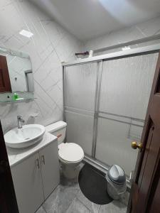 ein Badezimmer mit Dusche, Toilette und Waschbecken in der Unterkunft Departamentos en Cuenca in Cuenca
