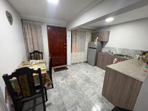 eine kleine Küche mit einem Tisch und einem Kühlschrank in der Unterkunft Departamentos en Cuenca in Cuenca