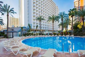 a swimming pool with lounge chairs and a hotel at SOL by Meliá Pelícanos Ocas in Benidorm