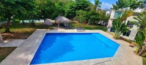 a large blue swimming pool in front of a house at Departamento Conjunto Mirador in Santa Cruz Huatulco