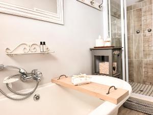 a bathroom with a bath tub with a shower and a fireplace at Normandie On Sea in Hermanus +68 photos
