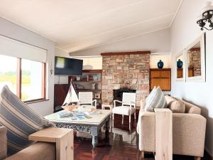 a living room with a couch and a fireplace at Normandie On Sea in Hermanus