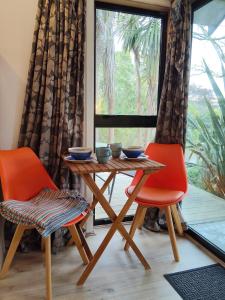 a table and two chairs in a room with a window at Mapua Cabbage Trees in Mapua
