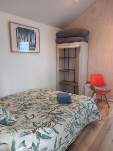 a bedroom with a bed and a red chair at Mapua Cabbage Trees in Mapua