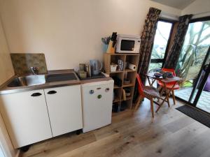 a kitchen with a sink and a table with a microwave at Mapua Cabbage Trees in Mapua +9 photos