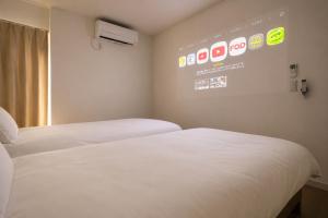 two beds in a room with a sign on the wall at BALOH Wadamisaki in Kobe +28 photos