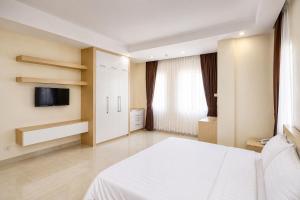 a bedroom with a white bed and a tv at Phnom Penh Star Apartment in Phnom Penh