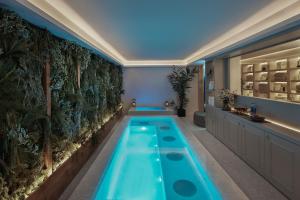 a swimming pool in a hotel room with a plant wall at MiM Ibiza member of Meliá Collection in Ibiza Town