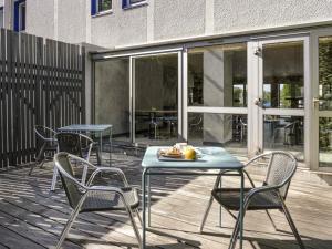a patio with chairs and a table with a plate of food on it at ibis budget Arles Sud Fourchon in Arles