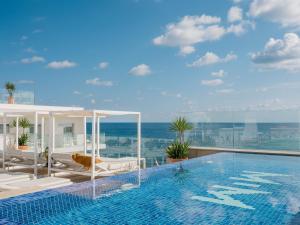 a swimming pool with a view of the ocean at MiM Mallorca member of Meliá Collection in Sa Coma