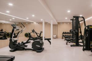 a gym with treadmills and elliptical machines at MiM Mallorca member of Meliá Collection in Sa Coma