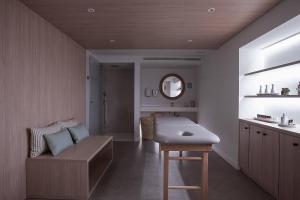 a bathroom with a bench and a sink and a mirror at MiM Mallorca member of Meliá Collection in Sa Coma +68 photos
