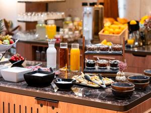a kitchen counter with food and drinks on it at Mercure Villefranche-sur-Saône in Villefranche-sur-Saône