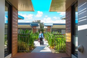 a man walking down a walkway in a house at Room Motels Kingaroy in Kingaroy