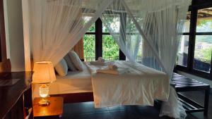 a woman laying on a bed in a room with a window at Turn View Resort Ella in Ella