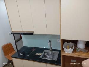 a kitchen with white cabinets and a sink at Nam Thanh Hotel in Nhật Tựu