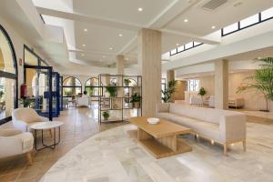 a lobby with a couch and chairs and a table at SOL by Meliá Sancti Petri in Chiclana de la Frontera