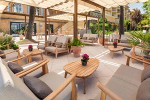 a patio with chairs and tables and umbrellas at Meliá Isla Canela in Isla Canela