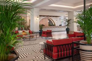 a lobby with red chairs and potted plants at Meliá Isla Canela in Isla Canela +99 photos