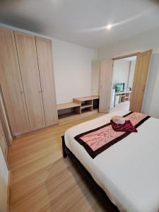 a bedroom with a large white bed and wooden cabinets at Happy Cottage in Chalong