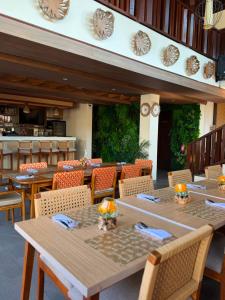 a dining room with wooden tables and chairs at The Kayangan Sanur in Sanur