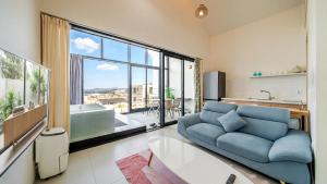 a living room with a blue couch and a large window at Gyeongju heybreeze Pool Villa in Gyeongju +18 photos
