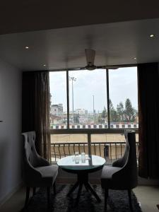 a room with a table and chairs and a large window at HOTEL DAISY in Guwahati