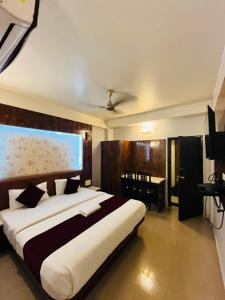 a bedroom with a large bed and a table at HOTEL DAISY in Guwahati