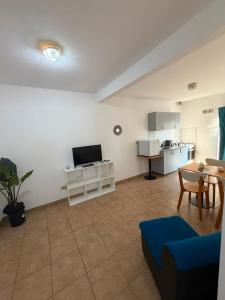a living room with a blue couch and a kitchen at Departamento en Ezeiza - SA in La Unión