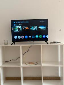 a flat screen tv sitting on top of a white shelf at Departamento en Ezeiza - SA in La Unión