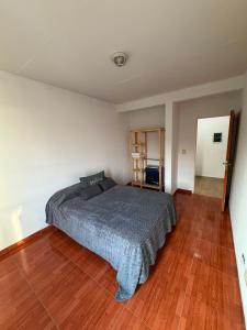 a bedroom with a bed and a wooden floor at Departamento en Ezeiza - SA in La Unión