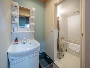 a white bathroom with a sink and a shower at Stay Maison Hida Takayama in Takayama