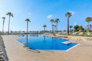 a pool at a resort with palm trees and chairs at SOL by Meliá Puerto Marina in Torremolinos