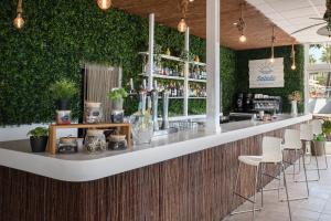 a bar with white chairs and a green wall at SOL by Meliá Puerto Marina in Torremolinos
