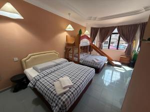 a bedroom with two beds and a childs bunk bed at Dino House in Taiping