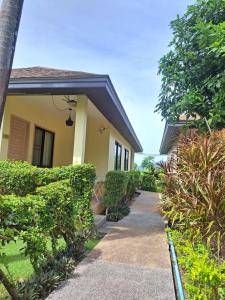a house with a walkway in front of it at Happy Cottage in Chalong