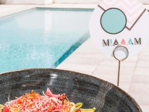 a bowl of food next to a swimming pool at Ibis Styles Toulouse Labège in Labège