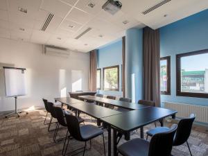 a conference room with tables and chairs and blue walls at Ibis Wroclaw Centrum in Wrocław