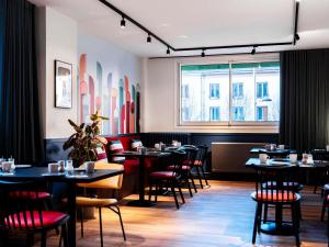 a restaurant with tables and chairs and a window at Ibis Styles Rouen Centre Cathédrale in Rouen
