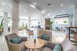 an office lobby with chairs and a table at Hotel Las Arenas, Affiliated by Meliá in Benalmádena