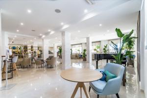 a lobby with a table and chairs and a piano at Hotel Las Arenas, Affiliated by Meliá in Benalmádena +41 photos